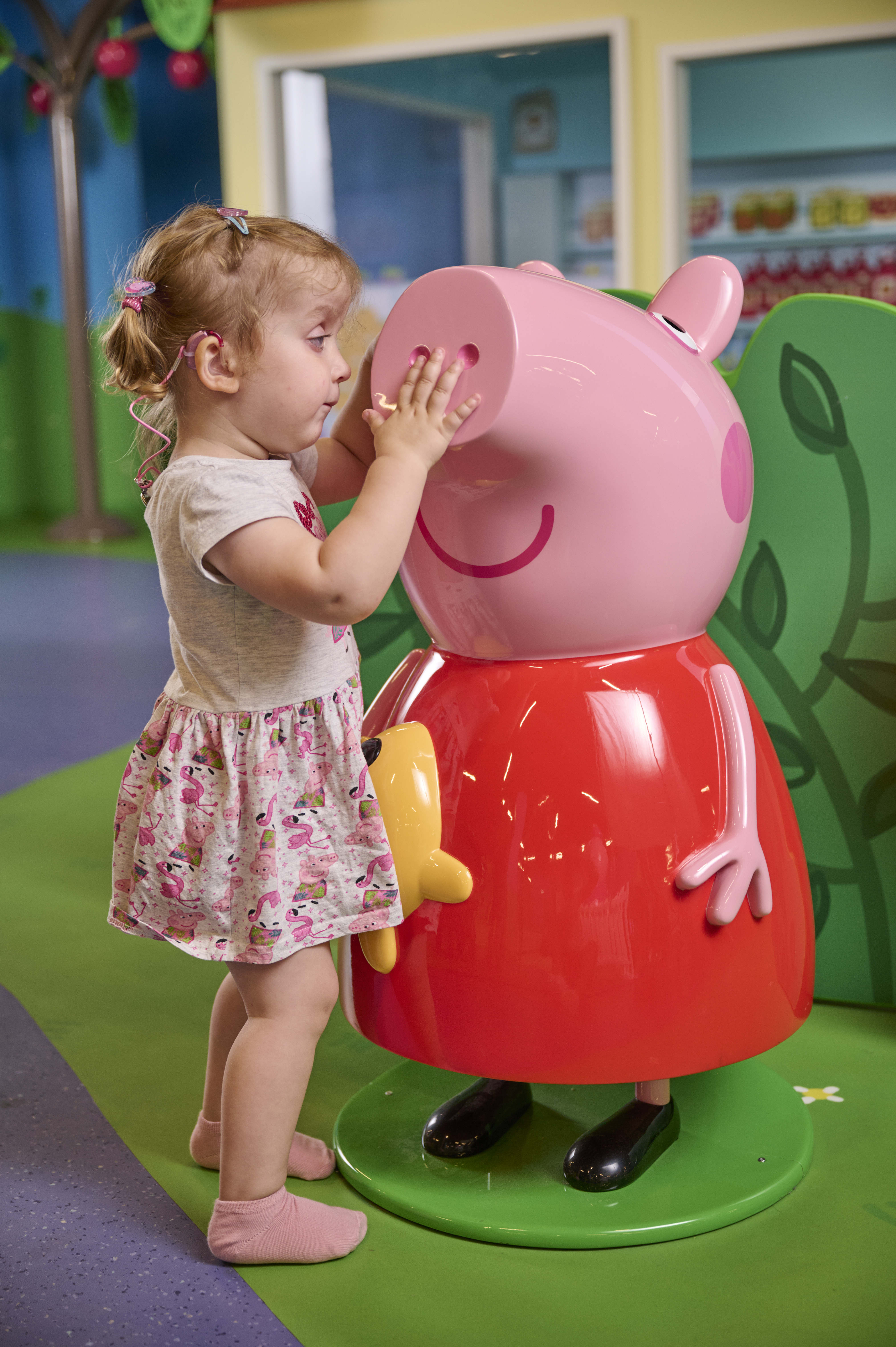 A young girl wit h visual impairment touches Peppa Pig 